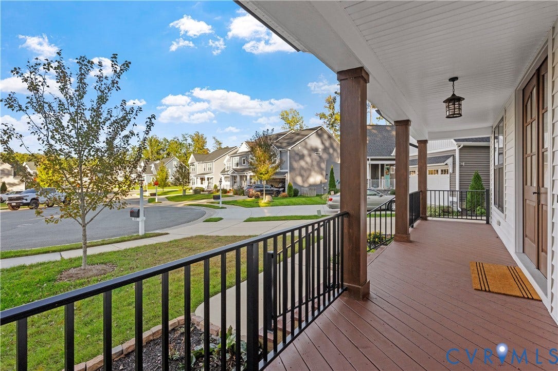 2613 Lilybank Place, NewMarket At RounTrey, Midlothian, VA 23112 Covered front porch featuring wood-finish decking, black metal railings, square architectural columns, and a hanging outdoor light fixture