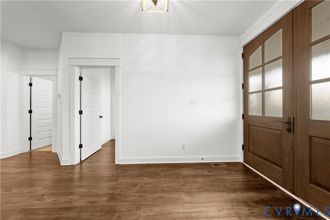 2613 Lilybank Place, NewMarket At RounTrey, Midlothian, VA 23112 Double entry doors with multi-lite frosted glass panels, wood-finish flooring, two-panel interior doors with dark hardware, and a ceiling-mounted geometric light fixture