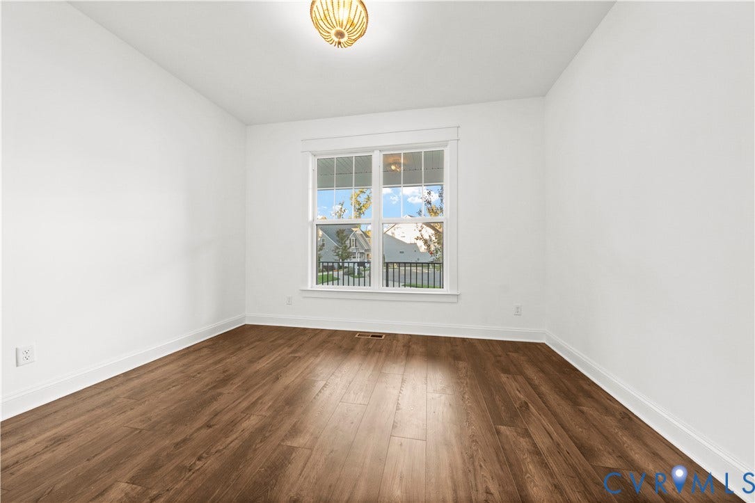 2613 Lilybank Place, NewMarket At RounTrey, Midlothian, VA 23112 Room featuring wood-finish flooring, a multi-pane window with custom trim, and a globe-style flush-mount light fixture