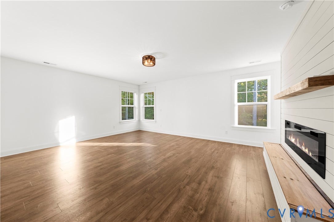 2613 Lilybank Place, NewMarket At RounTrey, Midlothian, VA 23112 Wood-finish flooring, white shiplap accent wall, built-in fireplace, natural wood mantel, and multi-pane windows