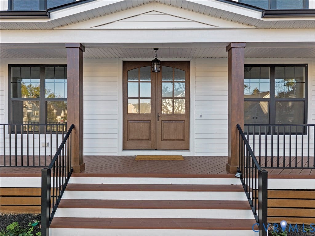 2613 Lilybank Place, NewMarket At RounTrey, Midlothian, VA 23112 Covered front porch featuring wood-finish decking, structural support columns, metal railing, and double-entry doors with glass pane detailing