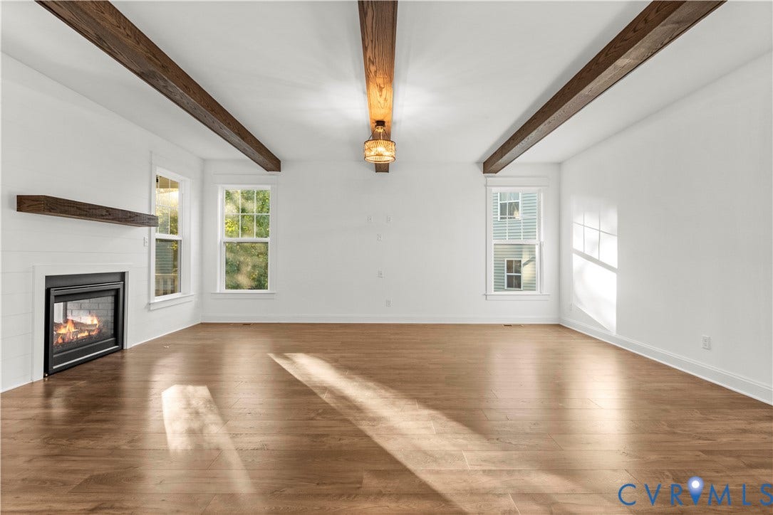 2613 Lilybank Place, NewMarket At RounTrey, Midlothian, VA 23112 Living area featuring wood-finish flooring, exposed stained-wood ceiling beams, wood-trimmed fireplace mantel, and multipane windows