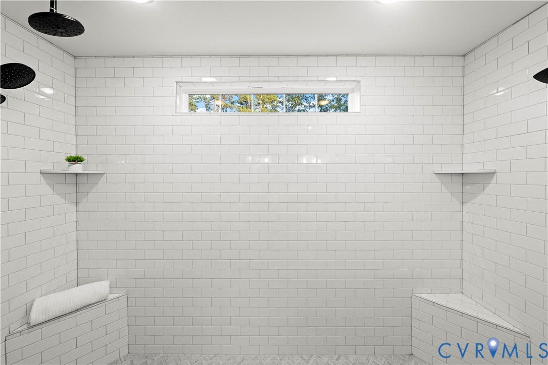 2613 Lilybank Place, NewMarket At RounTrey, Midlothian, VA 23112 Walk-in shower featuring white subway tile surround, dual wall-mounted rainfall shower heads, integrated stone-topped bench seating, and a transom window
