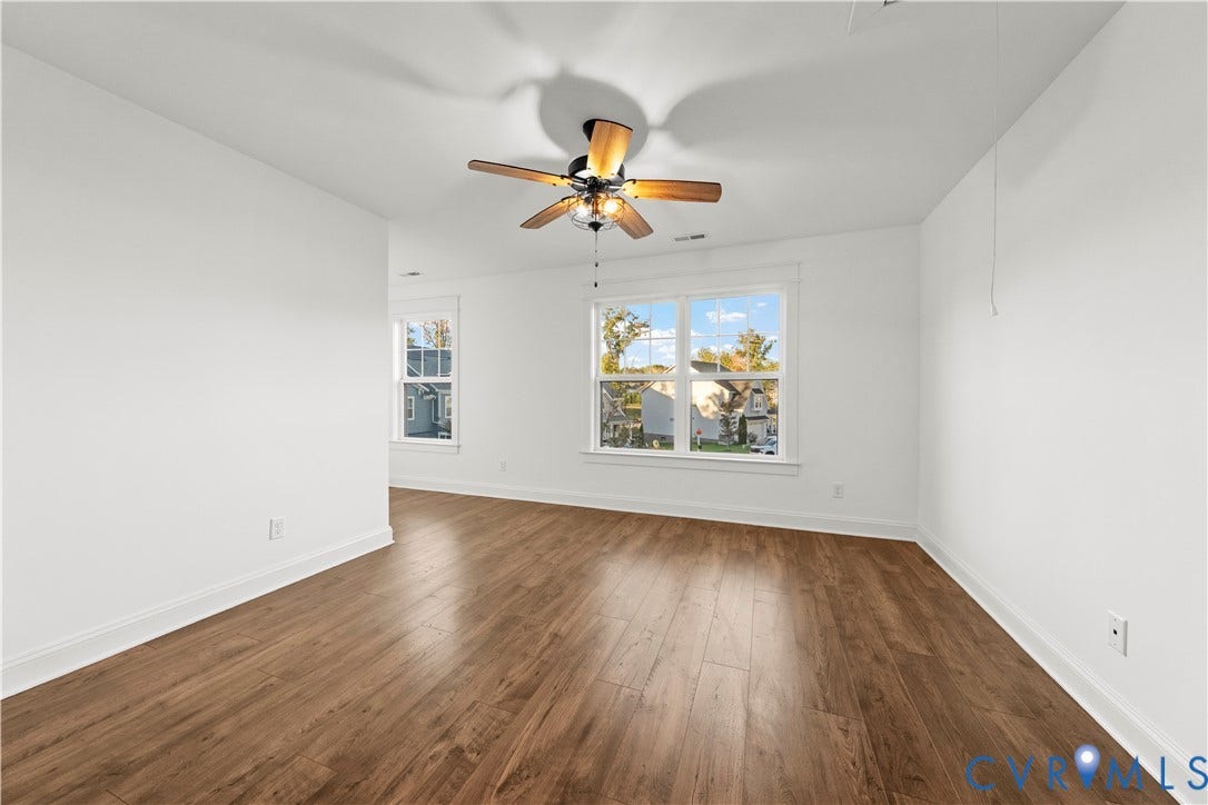 2613 Lilybank Place, NewMarket At RounTrey, Midlothian, VA 23112 Room featuring wood-finish flooring, white walls, dual-pane windows, and a ceiling fan with integrated lighting