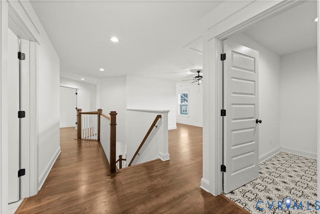 2613 Lilybank Place, NewMarket At RounTrey, Midlothian, VA 23112 Wood-finish flooring, staircase with a wood handrail and white balusters, five-panel interior doors, and patterned tile flooring