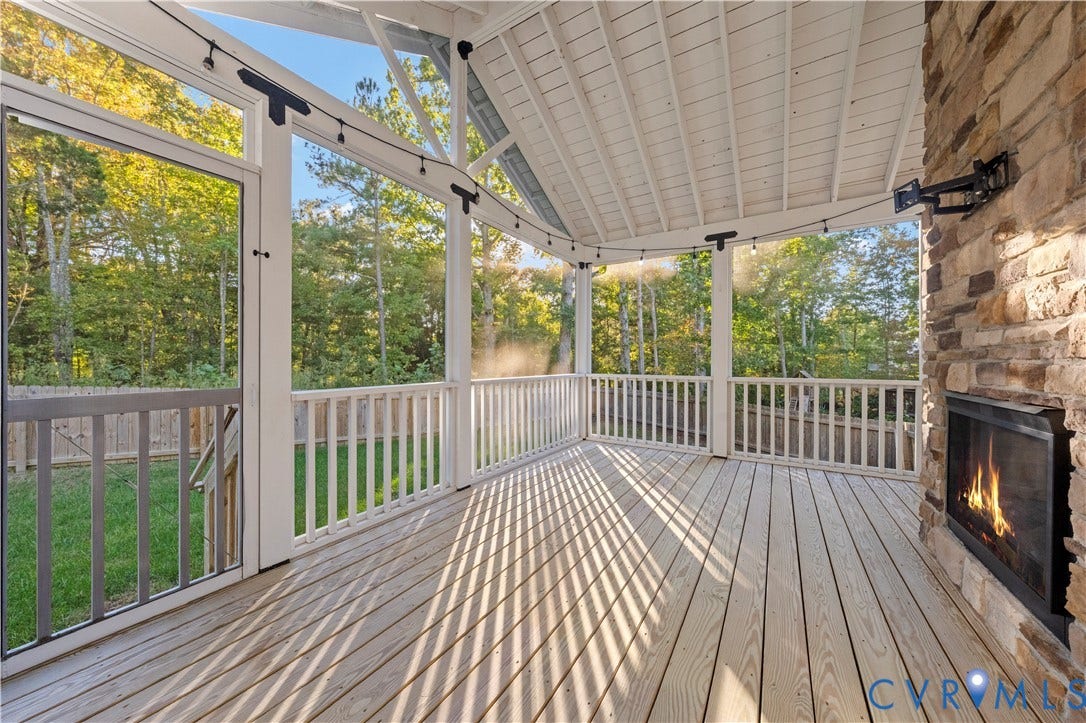 2613 Lilybank Place, NewMarket At RounTrey, Midlothian, VA 23112 Screened porch featuring a natural wood deck, stone-surround fireplace, vaulted ceiling, and white railing