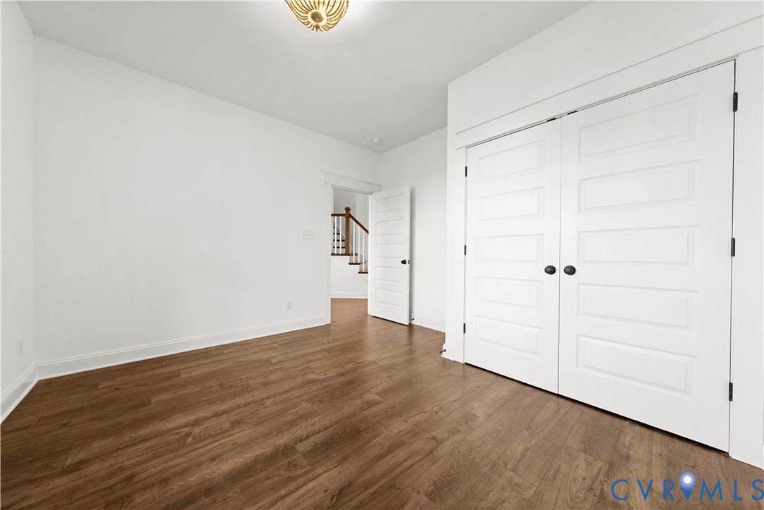 2613 Lilybank Place, NewMarket At RounTrey, Midlothian, VA 23112 Room featuring wood-finish flooring, white five-panel interior doors, and a decorative flush-mount ceiling fixture