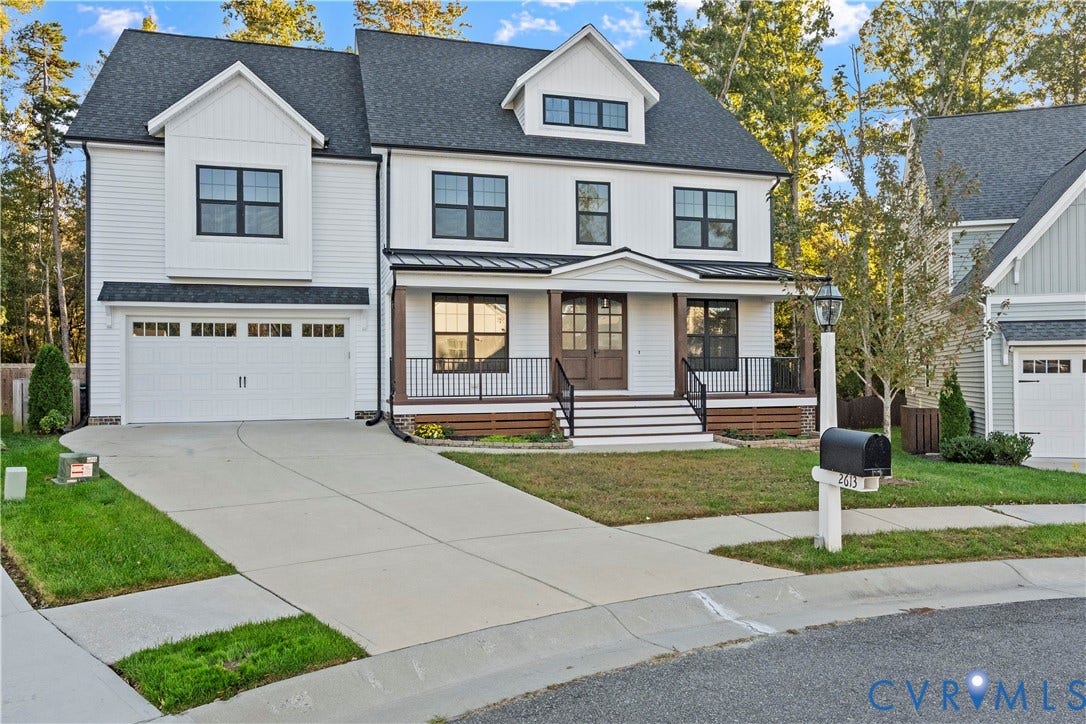 2613 Lilybank Place, NewMarket At RounTrey, Midlothian, VA 23112 Two-story residence featuring white horizontal siding, a covered front porch with metal roofing, dark-stained double front entry doors, and a double-car garage