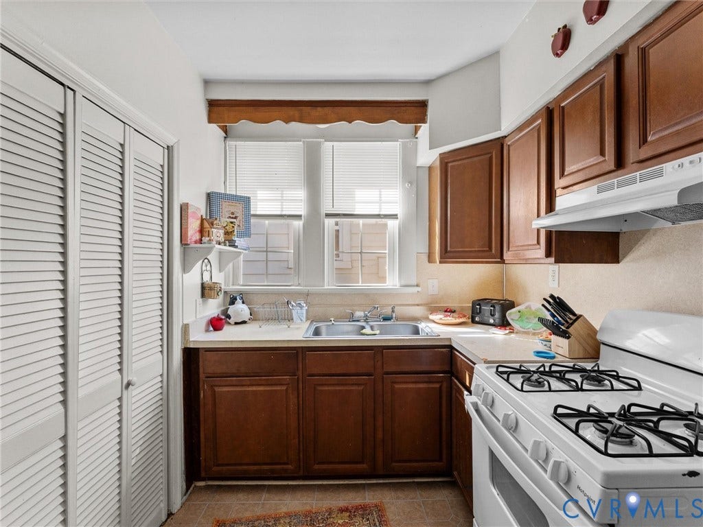 2305 Halifax Avenue, Oak Grove, Sandston, VA 23224 Kitchen featuring wood cabinetry, white double-door louvered pantry, dual-basin sink, and gas range with integrated vent hood