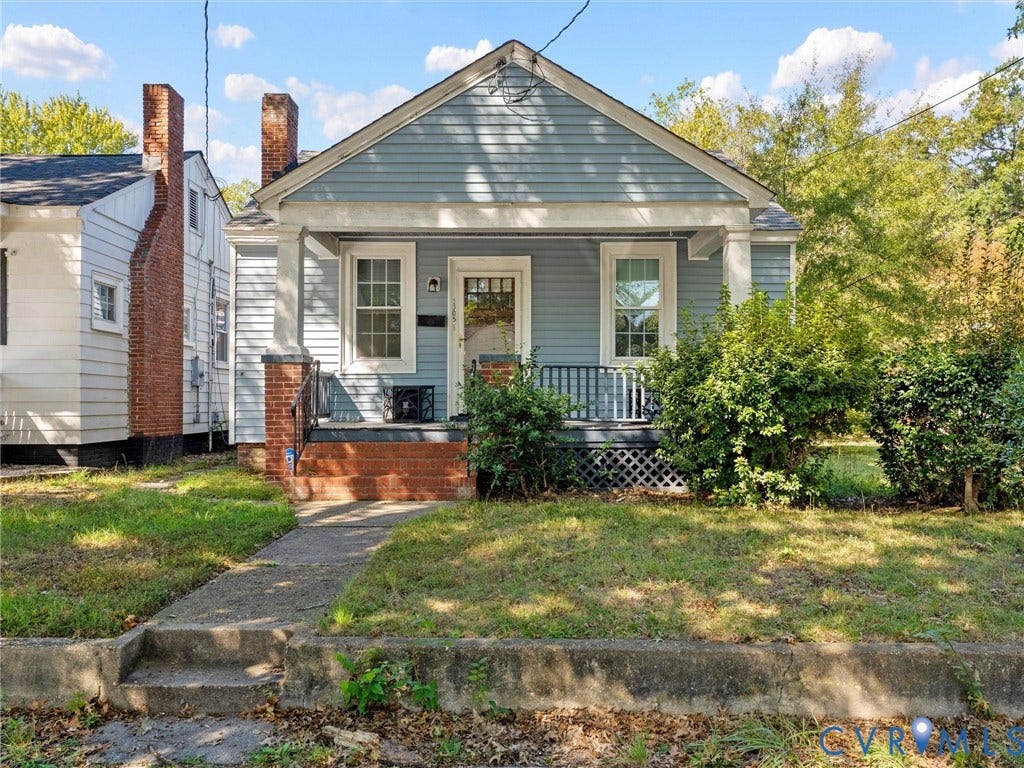 2305 Halifax Avenue, Oak Grove, Sandston, VA 23224 Blue horizontal siding exterior featuring a front-facing gable roof, a covered porch with tapered columns, a brick foundation, and multi-pane windows