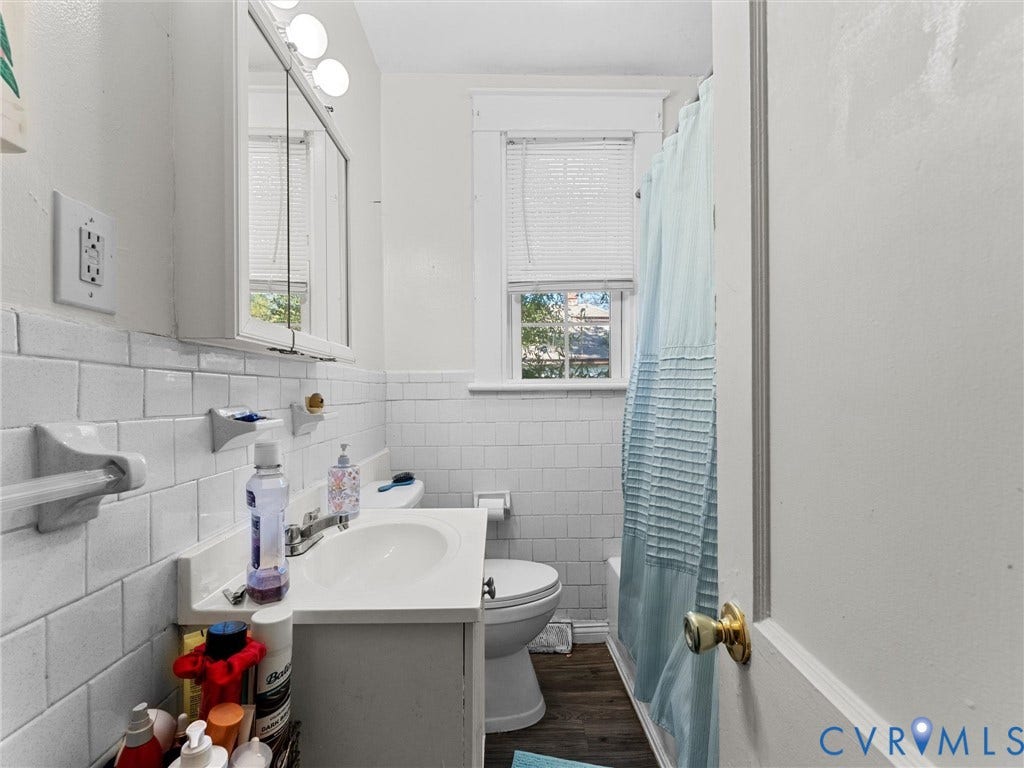 2305 Halifax Avenue, Oak Grove, Sandston, VA 23224 Bathroom featuring white subway tile wall cladding, wood-finish flooring, a white vanity with an integrated sink, a mirrored medicine cabinet, and a window with trim detail