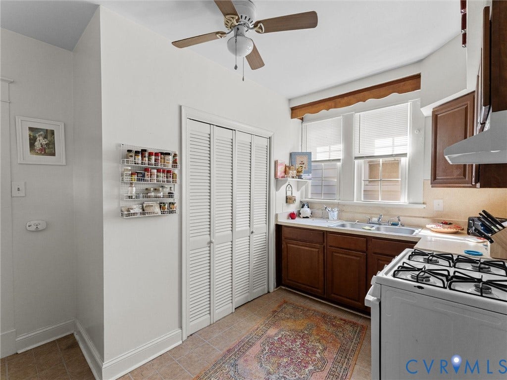 2305 Halifax Avenue, Oak Grove, Sandston, VA 23224 Kitchen featuring wood cabinetry, stainless steel double-basin sink, gas range, louvered-door pantry, and ceiling fan