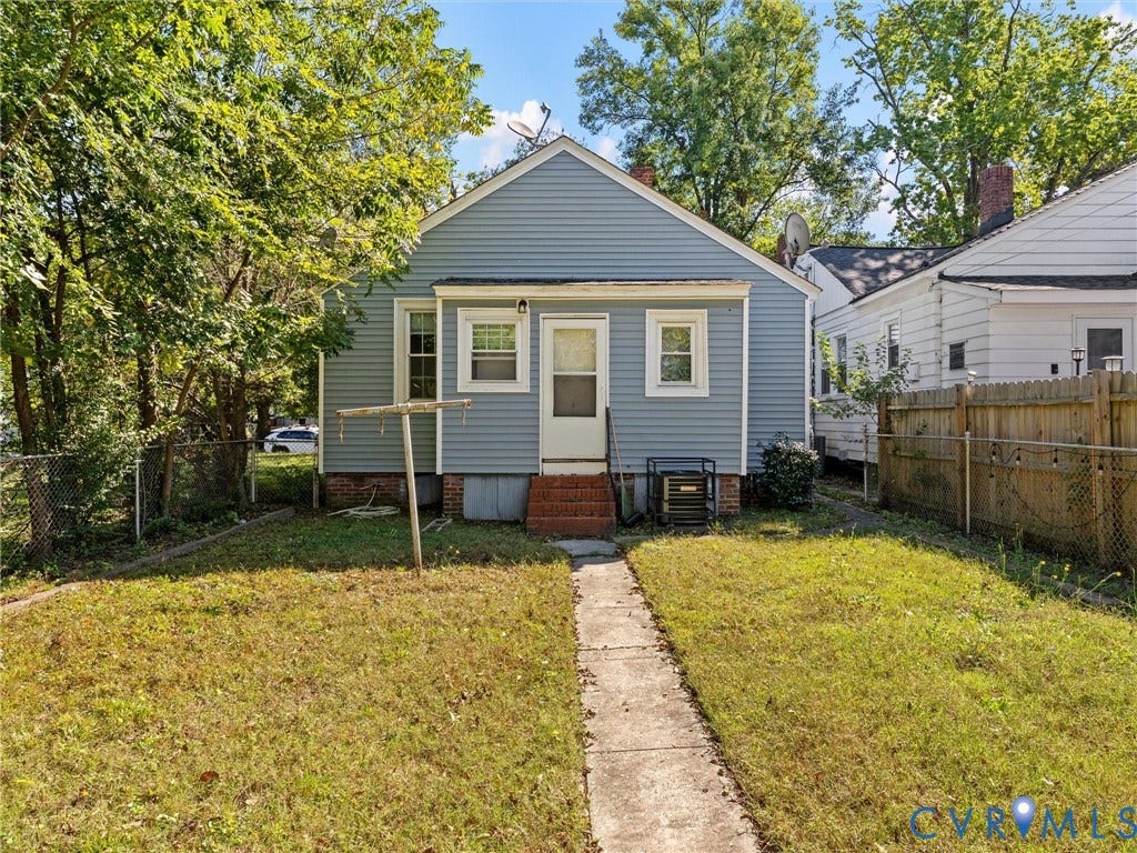 2305 Halifax Avenue, Oak Grove, Sandston, VA 23224 Exterior profile featuring light blue horizontal siding, brick foundation accents, a concrete walkway, and a fenced backyard