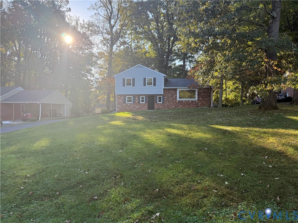 533 Williamsdale Drive, Midlothian, VA 23235 Two-story residence featuring a mixed brick and siding exterior, multi-pane windows, and a detached carport situated on a tree-lined lot