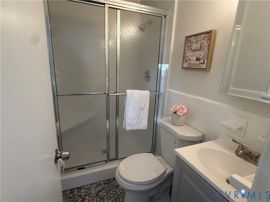 533 Williamsdale Drive, Midlothian, VA 23235 Bathroom featuring a walk-in shower with a sliding glass door, a vanity with an integrated sink, a solid-surface countertop, and penny-round tile flooring