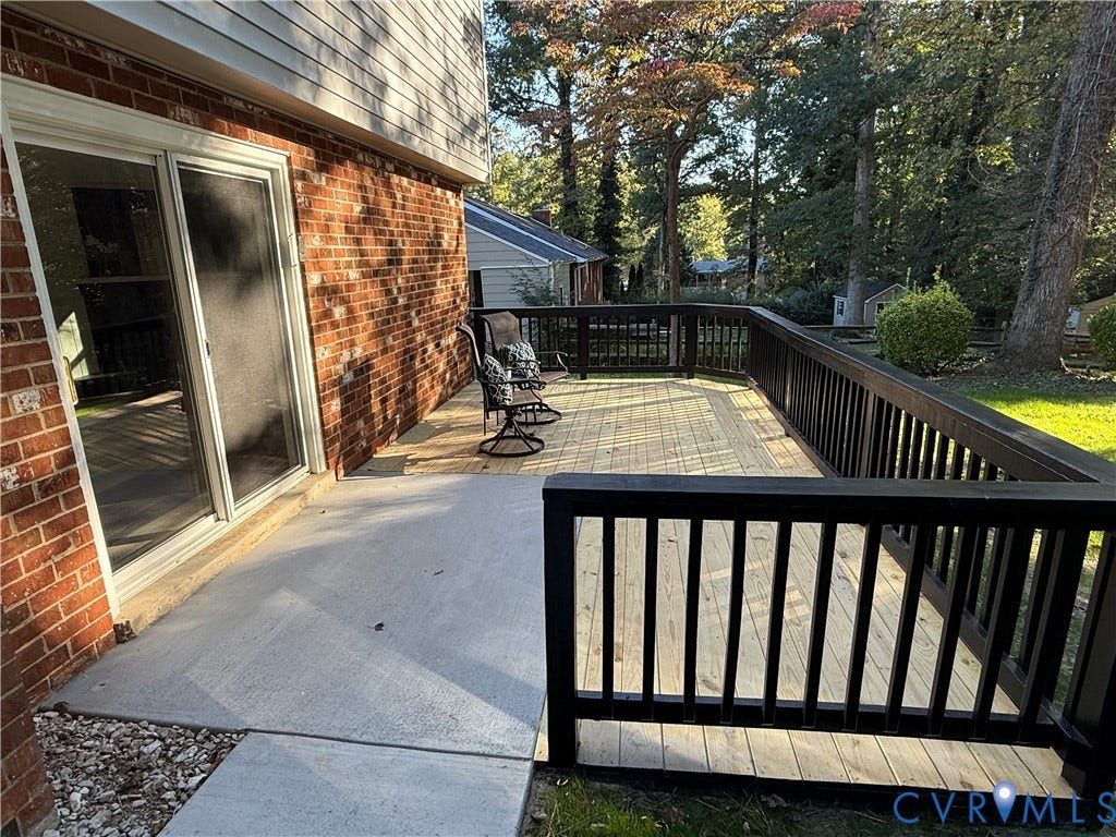 533 Williamsdale Drive, Midlothian, VA 23235 Multi-level exterior space featuring a concrete patio, wood-decking platform, black railing, brick siding, and a sliding glass door