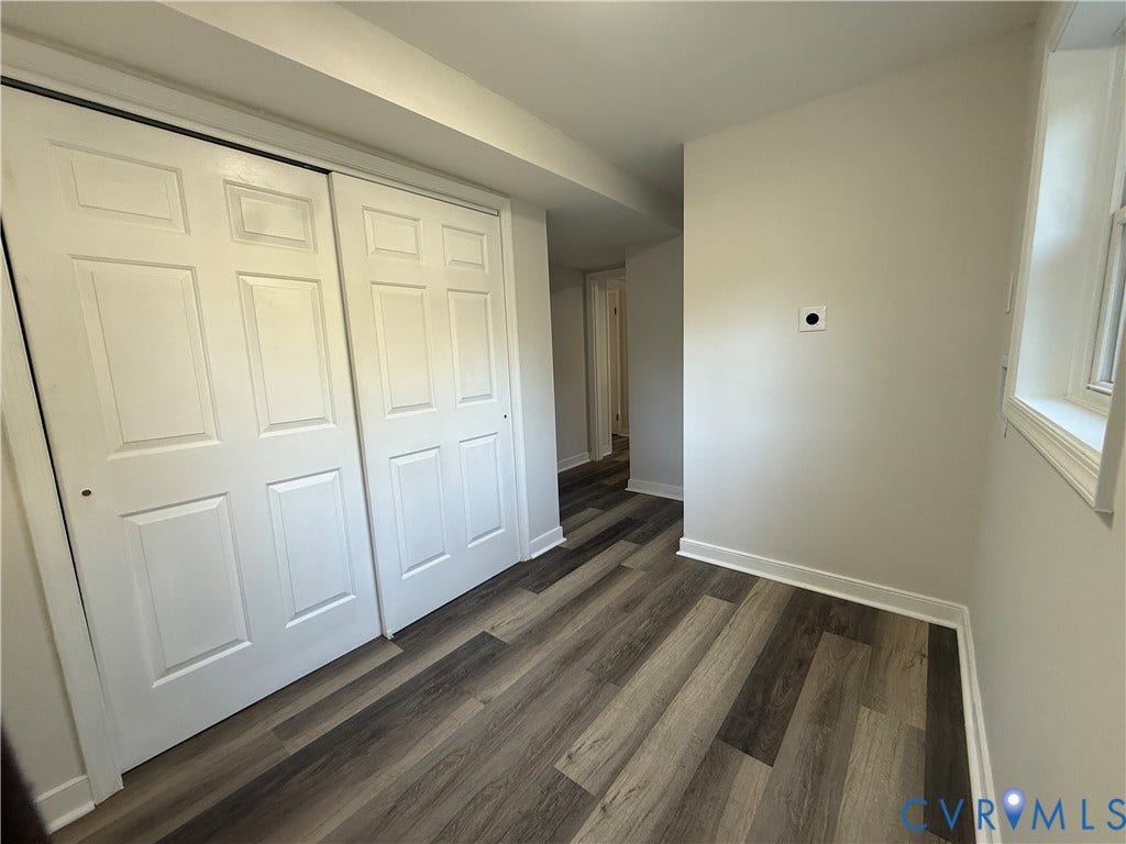 533 Williamsdale Drive, Midlothian, VA 23235 Neutral-toned walls paired with wood-finish flooring, featuring a dual-panel sliding closet and a window with white trim