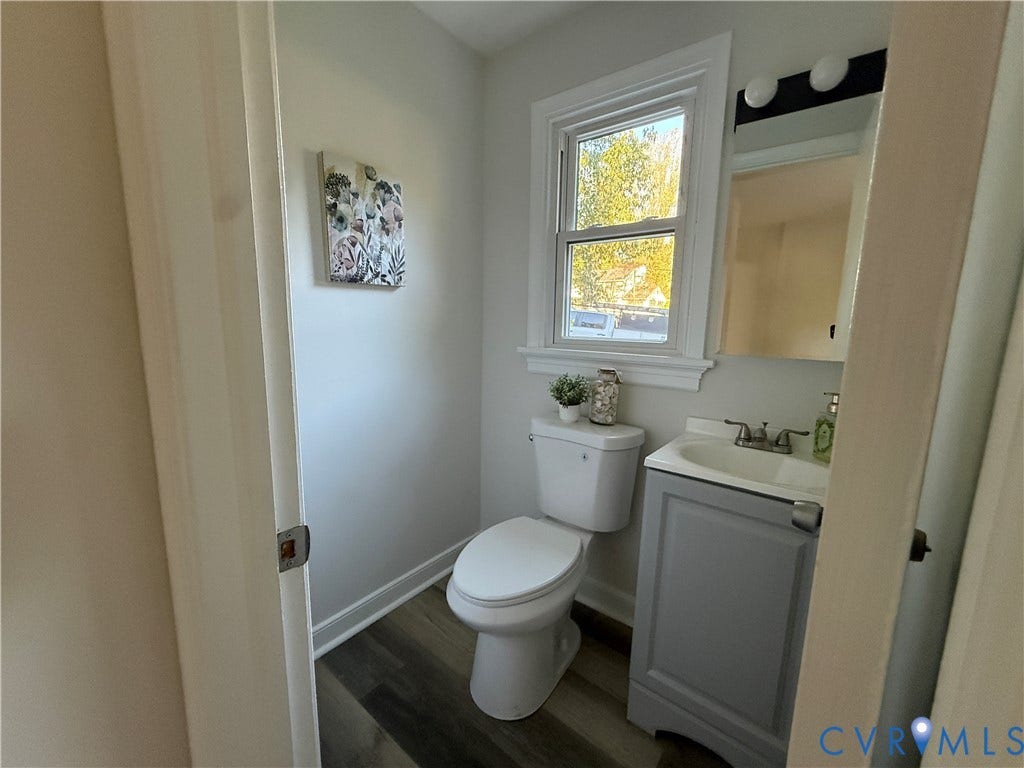 533 Williamsdale Drive, Midlothian, VA 23235 Neutral-toned interior featuring wood-finish flooring, a vanity with an integrated sink and chrome dual-handle faucet, a window with decorative molding, and a two-piece toilet