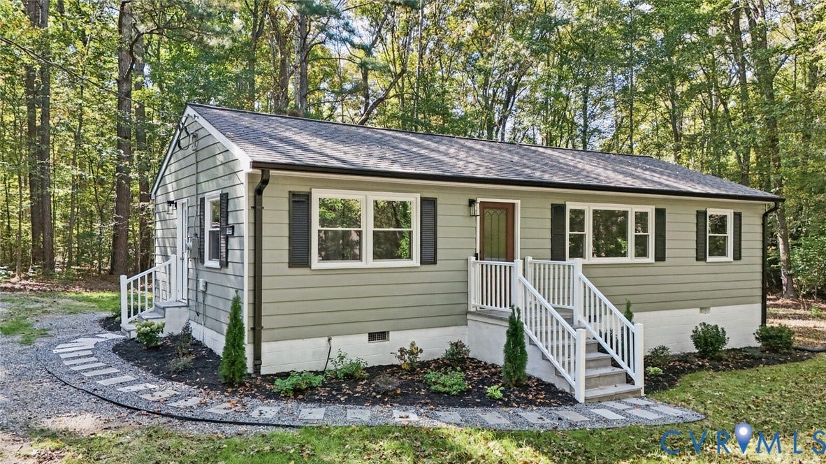 15227 Horseshoe Bridge Road, Hanover, VA 23047 Exterior featuring horizontal lap siding, white-railed entry steps, shuttered windows, and a stone paver walkway surrounded by mature trees