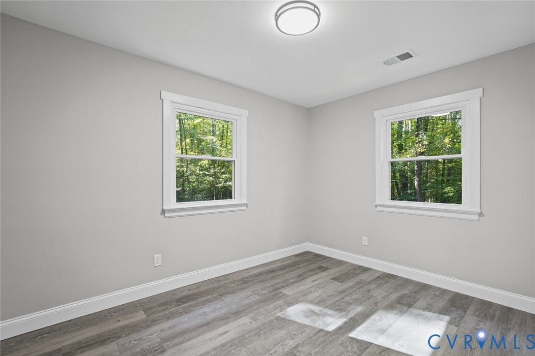 15227 Horseshoe Bridge Road, Hanover, VA 23047 Room featuring wood-finish flooring, neutral walls, two windows with white trim, and a ceiling-mounted light fixture