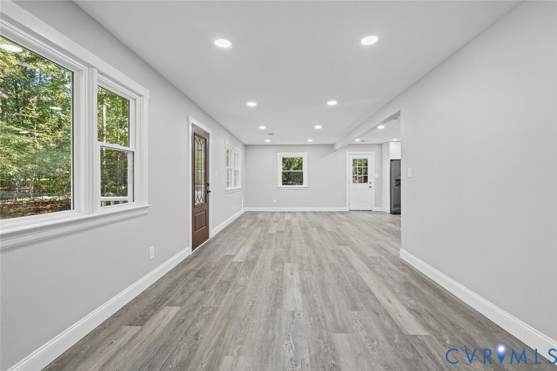 15227 Horseshoe Bridge Road, Hanover, VA 23047 Open-concept interior featuring wood-finish flooring, recessed lighting, multiple multi-pane windows, and a dark-toned exterior door with decorative glass inlay