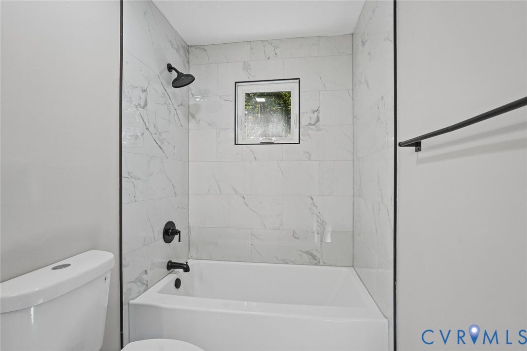 15227 Horseshoe Bridge Road, Hanover, VA 23047 Bathtub and shower surround featuring large-format white tile with grey veining, matte black fixtures, and a square window