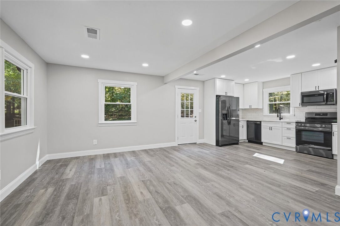 15227 Horseshoe Bridge Road, Hanover, VA 23047 Open-concept area featuring wood-finish flooring, recessed lighting, white shaker-style cabinetry, matte black hardware, and an integrated appliance suite
