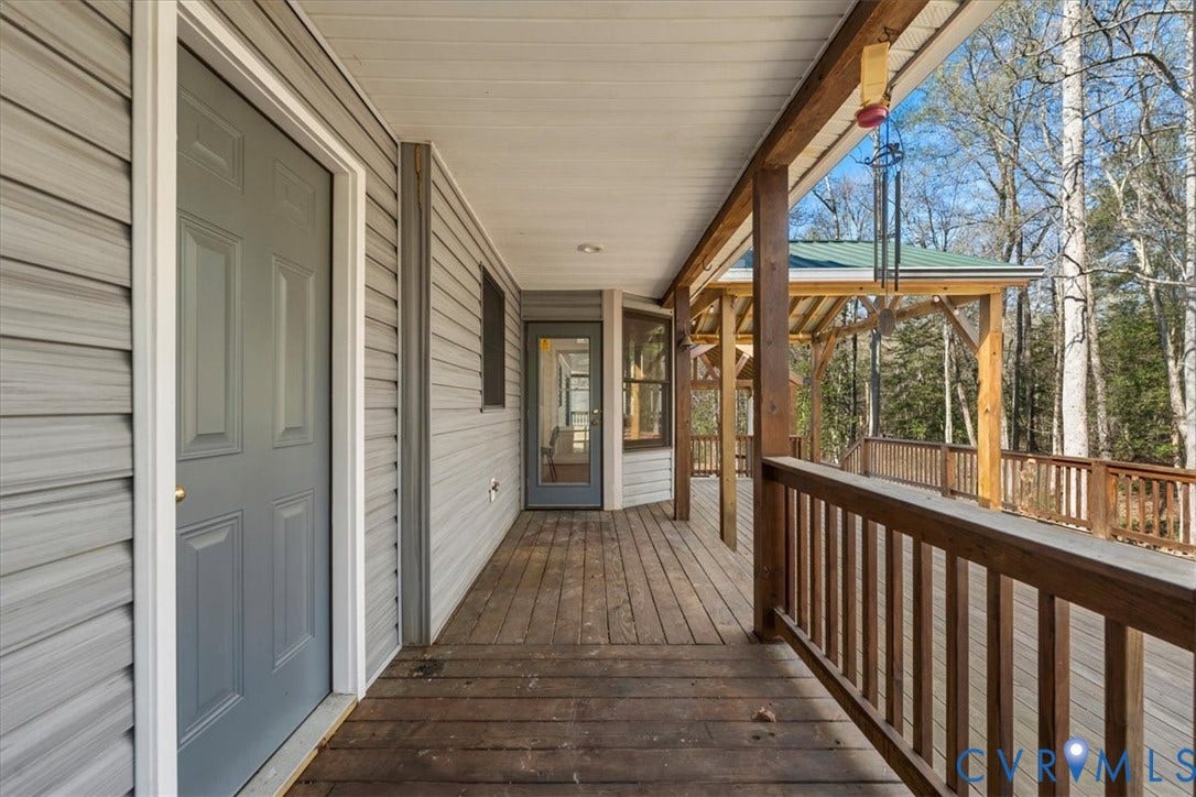7040 Old Roxbury Road, Average, New Kent, VA 23141 Covered wooden deck featuring horizontal siding, wooden balustrades, a built-in gazebo structure, and exterior doors