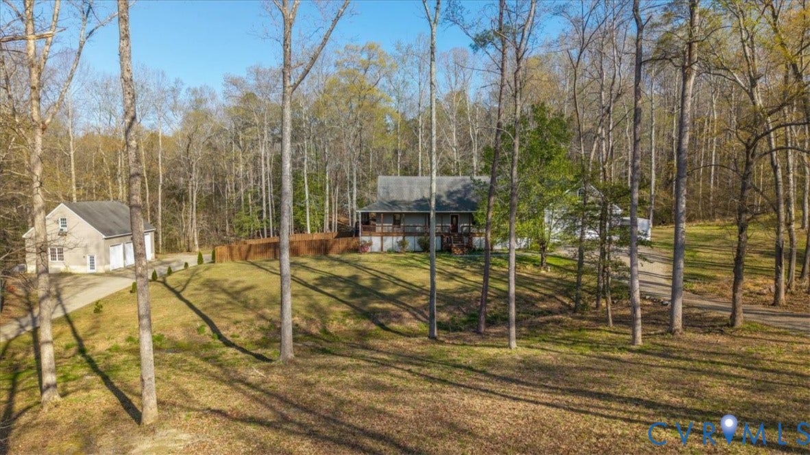 7040 Old Roxbury Road, Average, New Kent, VA 23141 Residential property featuring a sprawling lot with mature trees, a detached multi-car garage, and a wrap-around porch