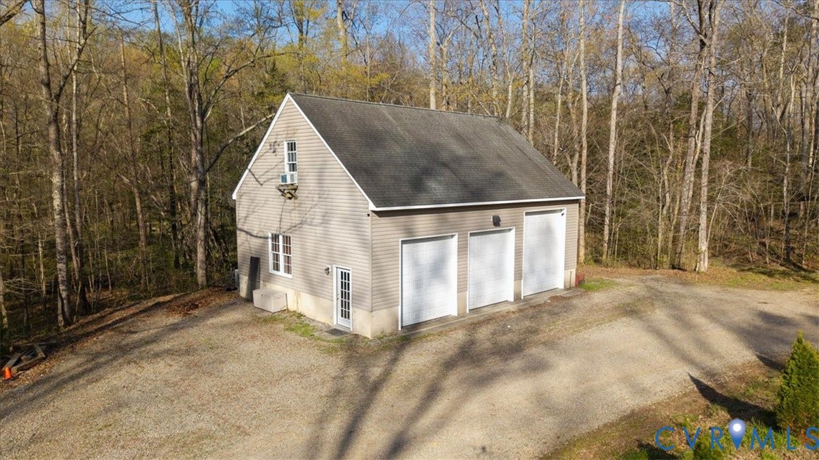 7040 Old Roxbury Road, Average, New Kent, VA 23141 Detached three-bay structure featuring light-colored vinyl siding, a gable roof, concrete foundation, and an expansive gravel driveway