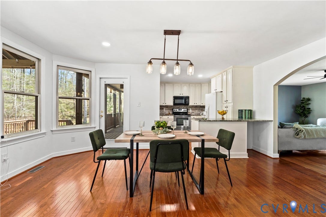 7040 Old Roxbury Road, Average, New Kent, VA 23141 Dining area featuring wood-finish flooring, multi-light linear pendant fixture, oversized bay windows, and glass-paneled exterior door