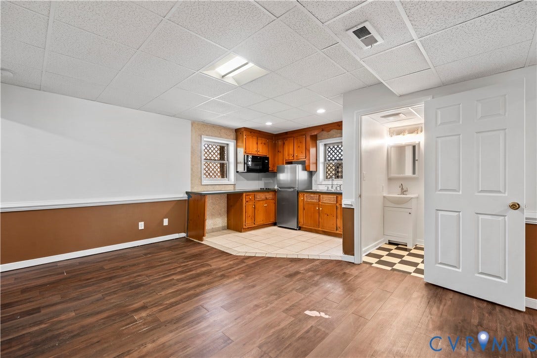 7040 Old Roxbury Road, Average, New Kent, VA 23141 Wood-finish flooring, drop ceiling with recessed lighting, kitchen featuring wood cabinetry and stainless steel appliances, ceramic tile kitchen flooring, and a private restroom with a pedestal sink