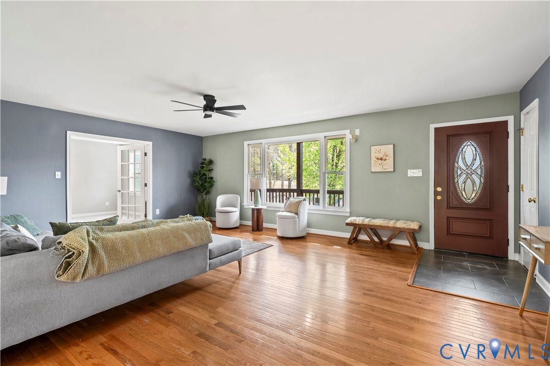 7040 Old Roxbury Road, Average, New Kent, VA 23141 Wood-finish flooring, dark-toned tile entry, multi-pane glass entry door with decorative inlay, large multi-panel window, and matte black ceiling fan