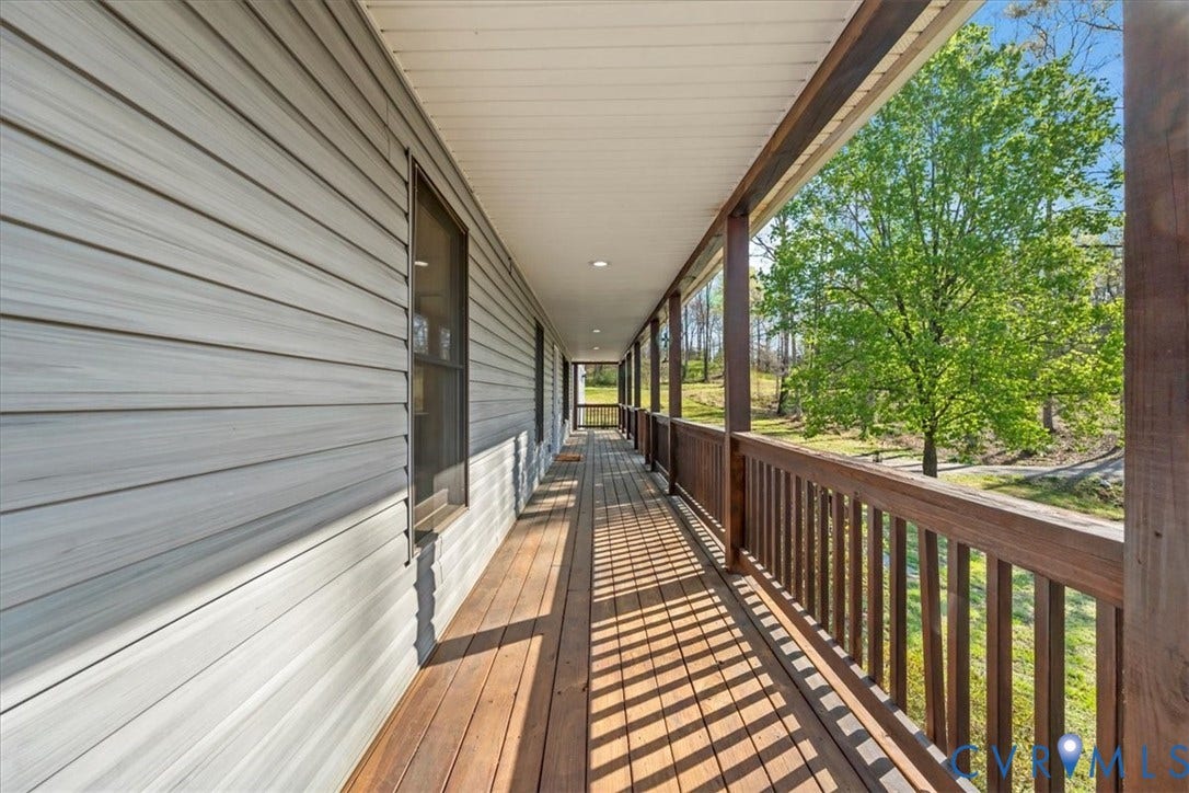 7040 Old Roxbury Road, Average, New Kent, VA 23141 Covered wrap-around porch featuring wood-finish decking, dark-stained wood railings, recessed lighting, and horizontal siding