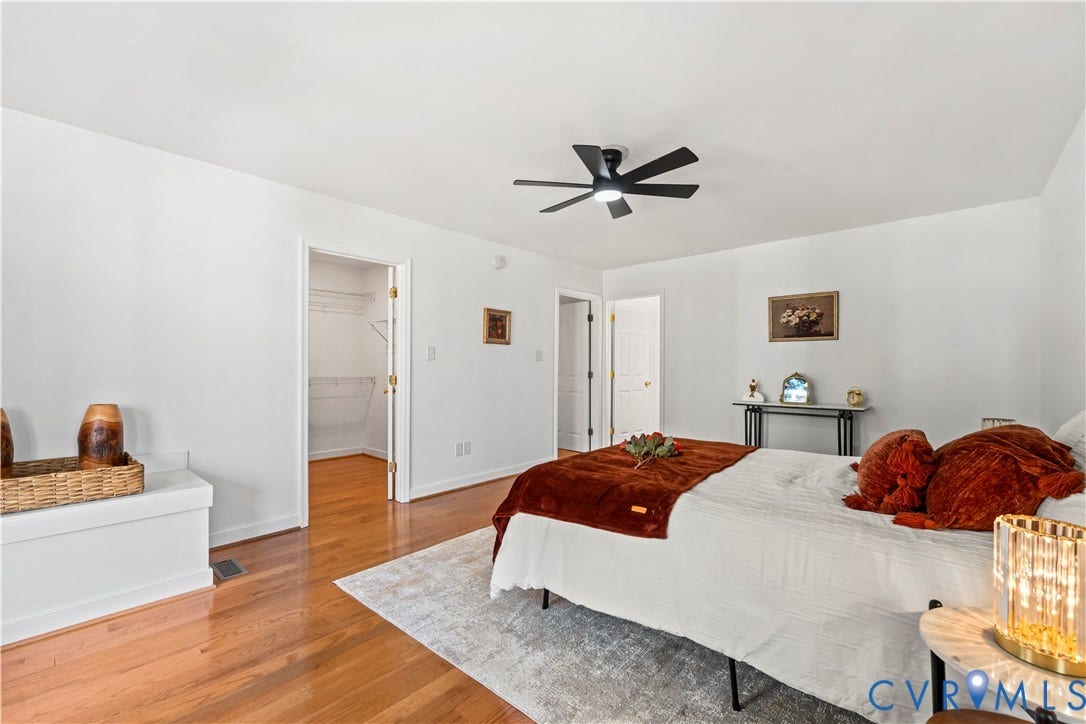7040 Old Roxbury Road, Average, New Kent, VA 23141 Wood-finish flooring, matte black ceiling fan, and walk-in closet featuring wire shelving