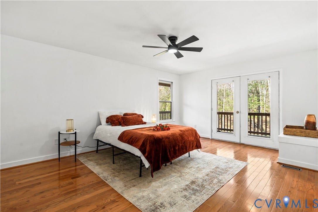 7040 Old Roxbury Road, Average, New Kent, VA 23141 Room featuring wood-finish flooring, a matte black ceiling fan with integrated lighting, and glass-paned double doors opening to an exterior deck