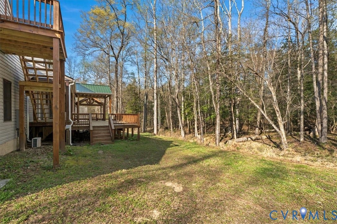 7040 Old Roxbury Road, Average, New Kent, VA 23141 Multi-level wood deck with a metal roof accent, expansive rear grounds, and mature wooded tree line