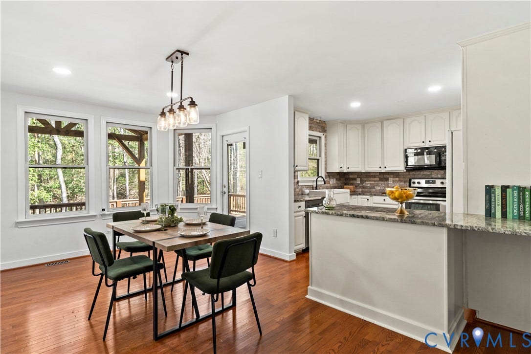 7040 Old Roxbury Road, Average, New Kent, VA 23141 Kitchen featuring white cabinetry, stone countertops, a tile backsplash, and wood-finish flooring, complemented by a multi-light pendant fixture over the dining area