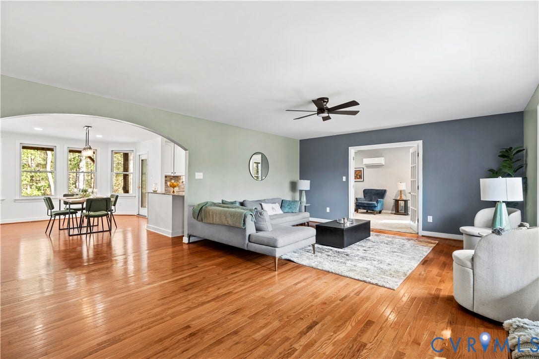 7040 Old Roxbury Road, Average, New Kent, VA 23141 Open-concept interior featuring wood-finish flooring, a prominent arched architectural opening, multiple windows, a ceiling fan, and French doors