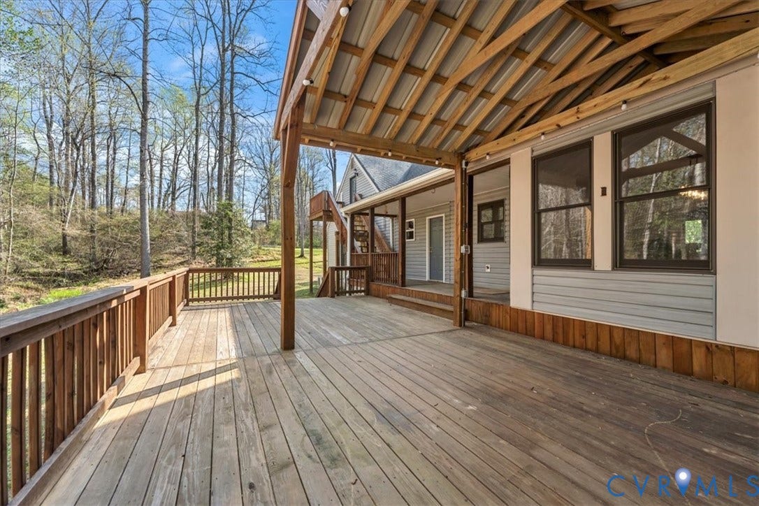 7040 Old Roxbury Road, Average, New Kent, VA 23141 Expansive wooden deck featuring a covered area with exposed timber framing, horizontal siding, and a wooden perimeter railing