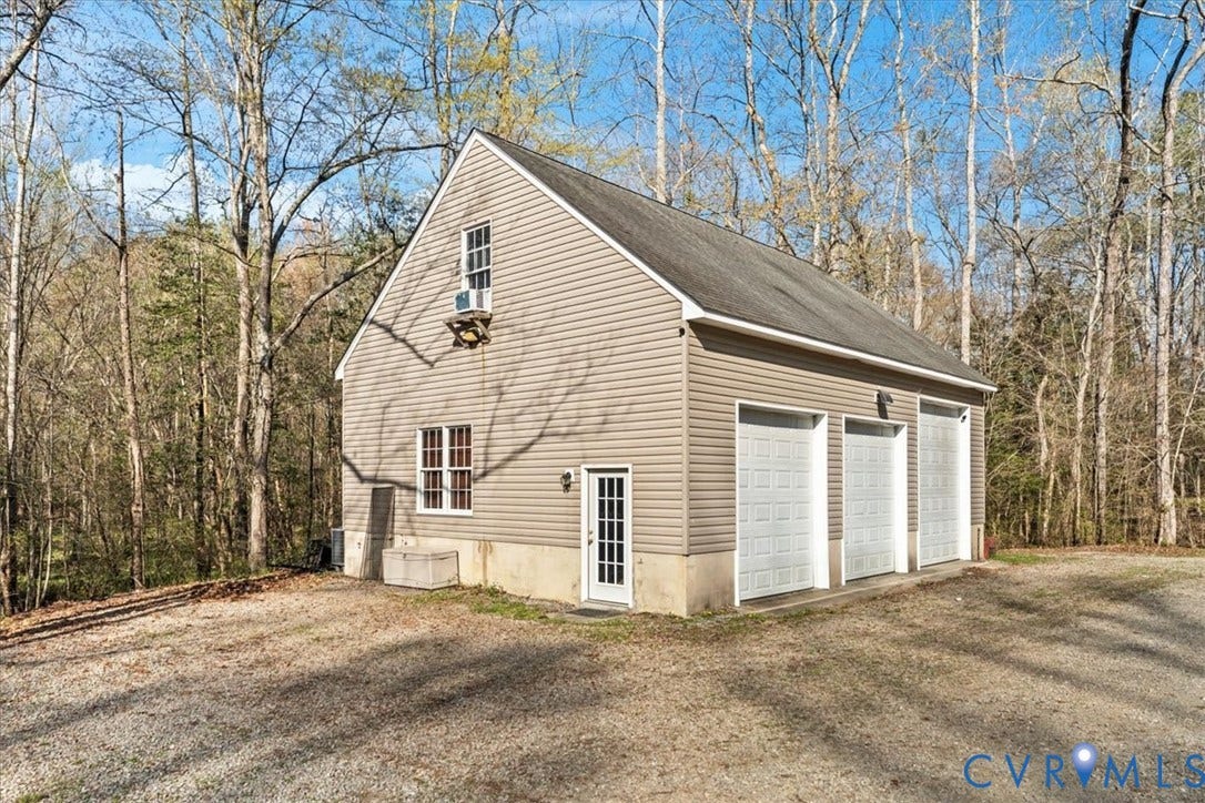7040 Old Roxbury Road, Average, New Kent, VA 23141 Detached structure featuring three garage bays, vinyl siding, a concrete foundation, and an exterior pedestrian door