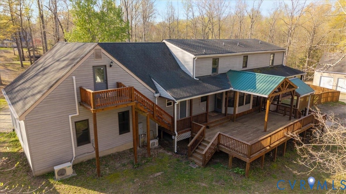 7040 Old Roxbury Road, Average, New Kent, VA 23141 Exterior featuring light gray vinyl siding, multi-level wood deck, metal-roofed covered porch area, and elevated wood balcony with stairs