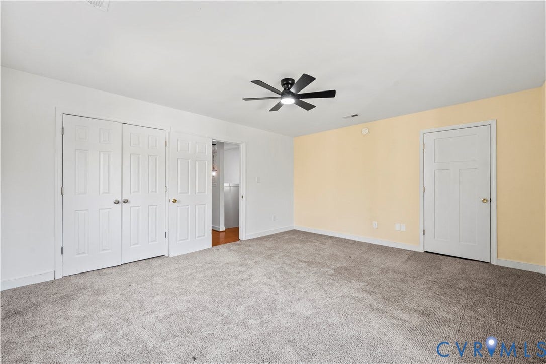 7040 Old Roxbury Road, Average, New Kent, VA 23141 Neutral-toned wall paint, wall-to-wall carpeting, white six-panel interior doors, and a black ceiling fan with integrated light fixture