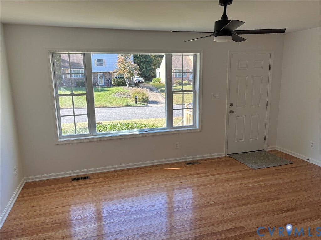 1708 Shewalt Drive, Fairfield, VA 23228 Living room featuring hardwood flooring, a large picture window, and a matte black ceiling fan