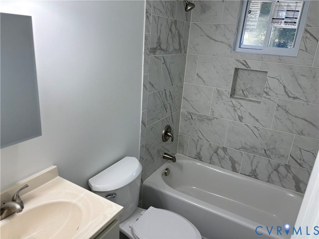 1708 Shewalt Drive, Fairfield, VA 23228 1st level Bathroom featuring a stone-look tile shower surround with a built-in recessed niche, tub-shower combination, vanity with an integrated sink, and metal finish fixtures