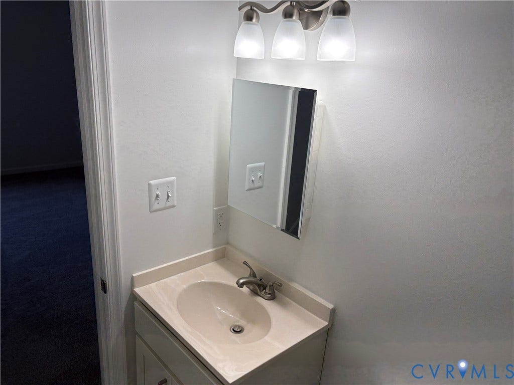 1708 Shewalt Drive, Fairfield, VA 23228 Vanity with integrated basin, solid-surface countertop, three-light brushed nickel fixture, and rectangular medicine cabinet