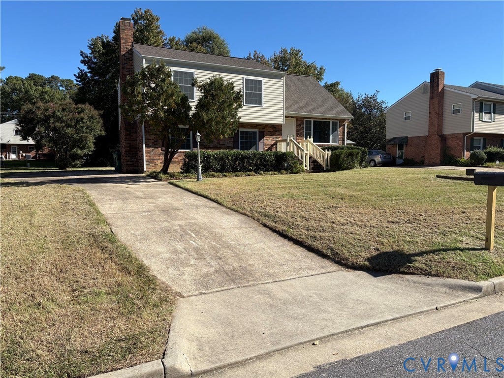 1708 Shewalt Drive, Fairfield, VA 23228 Split-level exterior featuring a brick and horizontal siding facade, a side-gable roofline, a prominent exterior chimney, and a concrete driveway