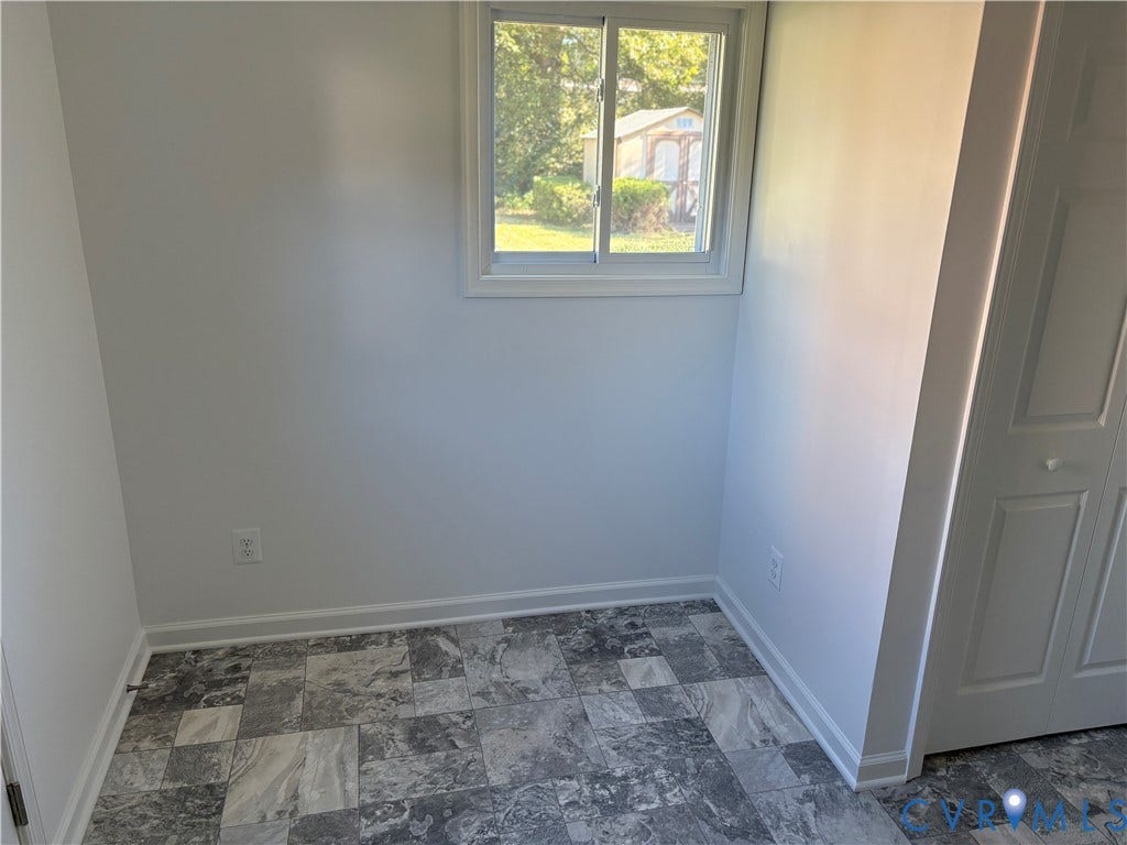 1708 Shewalt Drive, Fairfield, VA 23228 Utility Room featuring stone-patterned tile flooring, a sliding window with white trim, and a multi-panel closet door