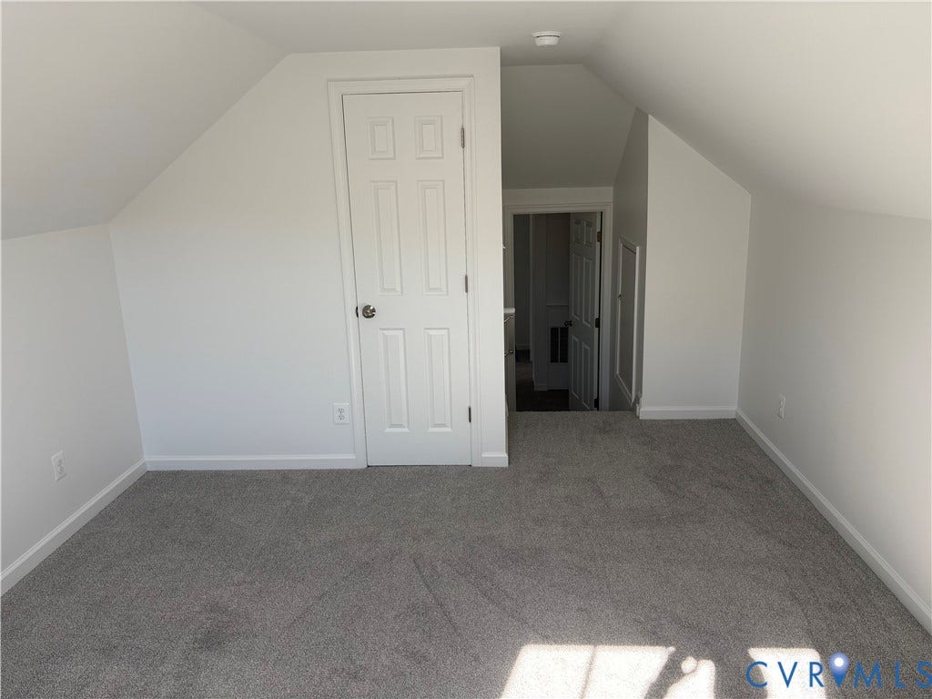 1708 Shewalt Drive, Fairfield, VA 23228 Finished attic space featuring vaulted ceilings, neutral carpeting, a six-panel interior door, and built-in access panel