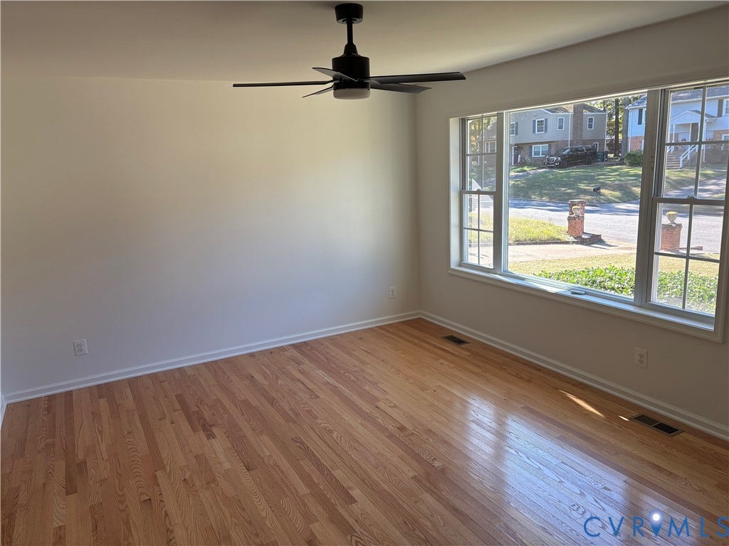 1708 Shewalt Drive, Fairfield, VA 23228 Living room featuring wood-finish flooring, a large multi-pane window, and a matte black ceiling fan